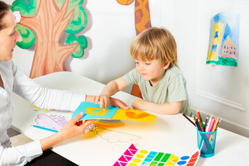 Early development lesson, woman shows letters to the boy