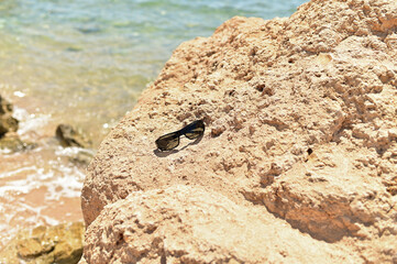 Background for cosmetics on the beach with sand. The podium is made of natural stone. A mock-up of a pedestal in the sunlight with a view of the sea.