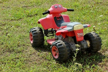 Obraz premium big children's red quad bike on green grass