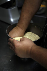 manos amasando masa para elaboración de pan artesanal - obrazy, fototapety, plakaty