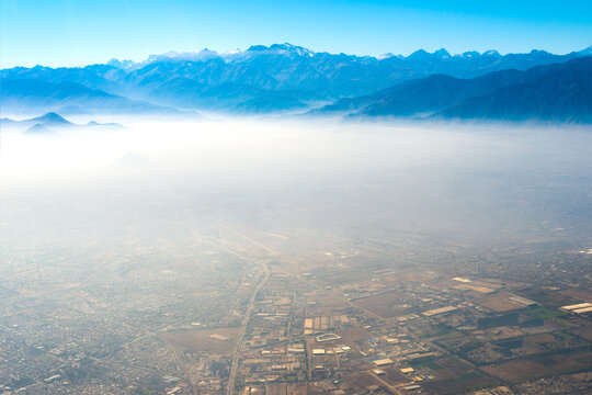 Aerial view of Santiago de Chile under a layer of smog with the Andes mountain range in the back