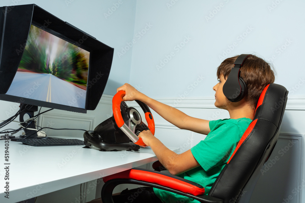 Wall mural Side portrait of boy, hands on steering wheel play race game