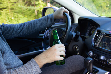 a man drives a car and drinks beer