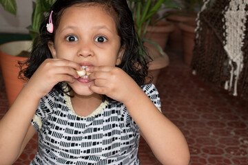 Girl eating homemade roasted healthy foxnut or lotus seeds or makhana for healthy lifestyle of...