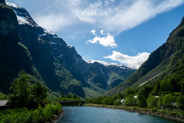 Fjord surrounded by green trees and high mountains in Norway