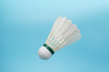 Badminton shuttlecock flying on blue background