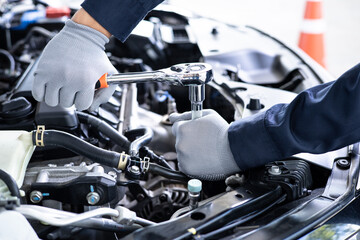 Close-up of a mechanic using a wrench to perform engine maintenance.