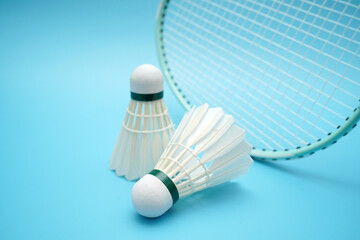 Badminton shuttlecock and badminton racket on blue background