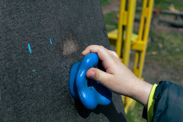 Little boy on the climbing wall. A child's hand is holding onto a ledge on a climbing wall
