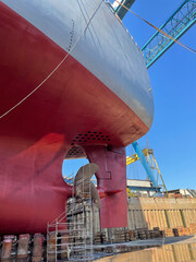 Dry-cargo ship in dry dock for repairs and maintenance at a shipyard.