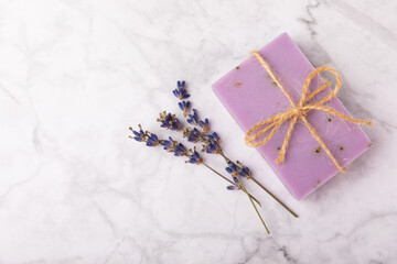 Handmade soap. Lavender spa. Lavender flowers and handmade soap. Natural herbal cosmetics with lavender flowers on a marble background.Copy space.Fletley