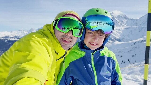 Selfie portrait of father and the boy in ski outfit