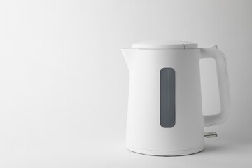 Modern electric kettle on white background, space for text