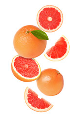 Tasty ripe grapefruits falling on white background