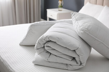 Soft folded blanket and pillows on bed indoors - obrazy, fototapety, plakaty