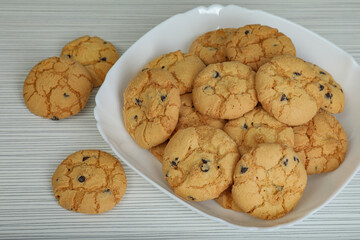Delicious cookies with chocolate on white wooden table, closeup