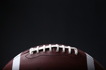 American football ball on black background, closeup. Space for text © New Africa