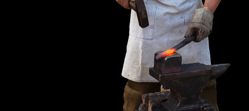 blacksmith forges red-hot workpiece on anvil on black background....
