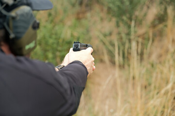 a man holds a gun in his hands. pistol shooting exercises