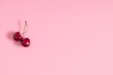 Red cherry on pink background. Ripe red cherry berries as background. Flat lay, top view, copy space