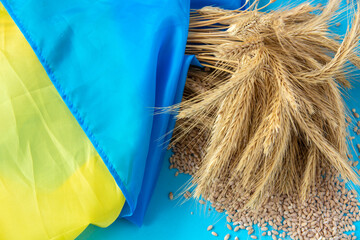 paper boat with Ukrainian flag, grain wheat and spikelets on a blue background. Ukraine grain...