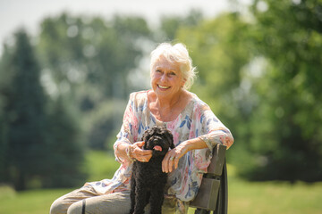 Senior Woman with Pet Dog outside in nature with poodle