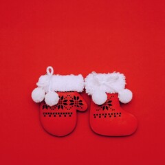 Festive decorative red Christmas Santa's mitten and boot on red background.Square Merry Christmas New Year greeting card