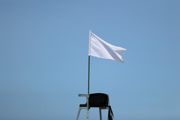 Biała  flaga na plaży oznacza że można pływać jest bezpiecznie.  - obrazy, fototapety, plakaty