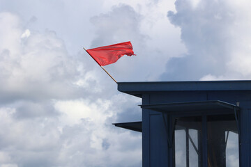 Czerwona flaga na plaży oznacza zakaz kąpieli bo sztorm - obrazy, fototapety, plakaty