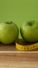 Green and fresh apples on wooden background and on green color