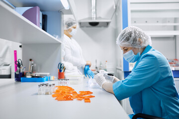 Women work in the lab. Conducts experiments on vaccines.