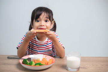 Girls eat breakfast on the table in the living room.