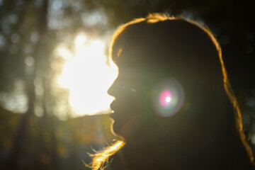 Defocus close-up silhouette of woman looking at sunrise. Mental health, hope, happiness concept. Dream autumn. Peace lifestyle. Open mind, new goals and decisions. Sunlight. Out of focus