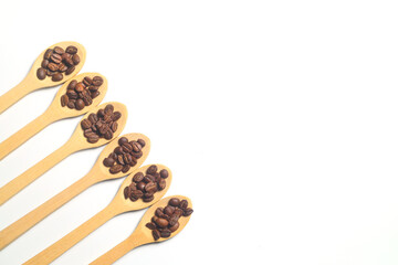 Coffee beans in a wooden spoon isolated on a white background. Roasted coffee beans isolated. A wooden spoon with coffee.