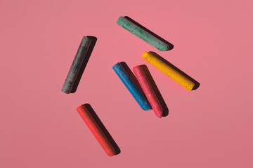 colored crayons on a pink background in hard light