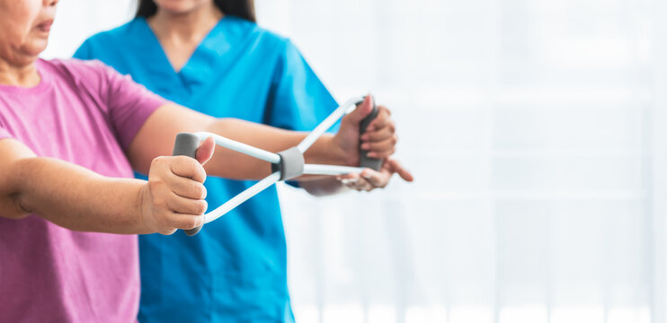 Blurred soft images of Physical therapist doing and using equipment to support arm muscles for elderly woman, to nursing home and health care concept.
