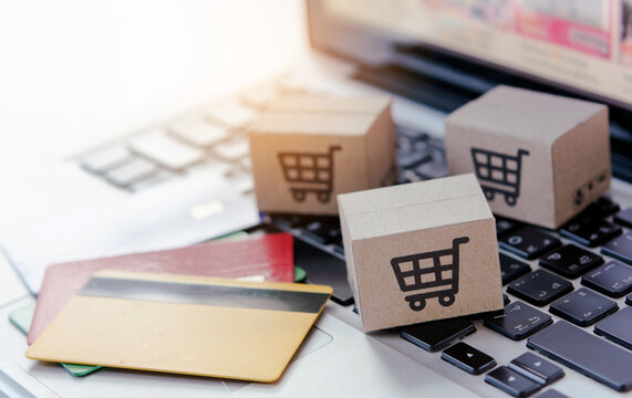 Shopping online. Credit card and cardboard box with a shopping cart logo on laptop keyboard. Shopping service on The online web. offers home delivery.