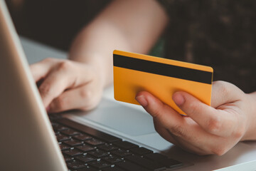 Credit card payment. Woman hands holding credit card and using laptop. Online shopping