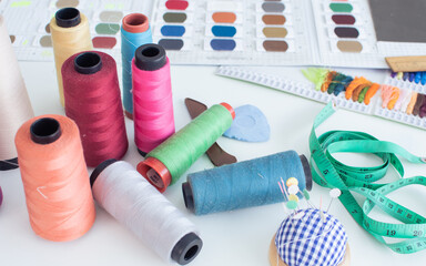 Selective focus of object colorful thread spools for sewing on table, interior tailor shop or room with nobody. Lifestyle and small business concept.