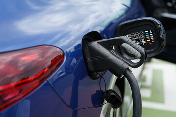 Modern EV electric car charging at home using green electric energy, future of transport concept