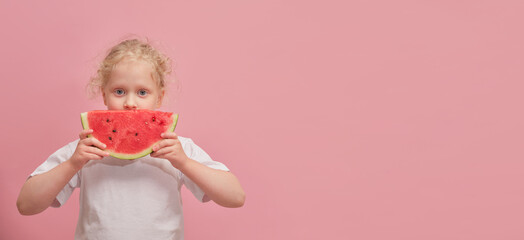 portrait happy young little girl is holding slice of watermelon over colorful pink background