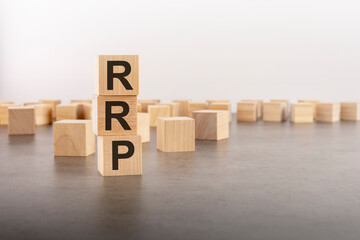 rrp text as a symbol on cube wooden blocks. many wooden blocks in the background.