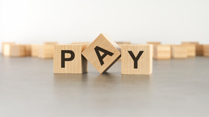 wooden cube with the letter from the PAY word. wooden cubes standing on gray background