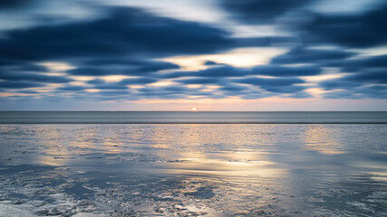 Beach at sunset (mud flat ) me passing clouds at mudflats