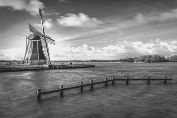 Dutch windmill at a lake with dynamic cloudscape