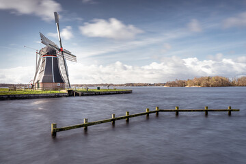 Dutch windmill at a lake with dynamic cloudscape