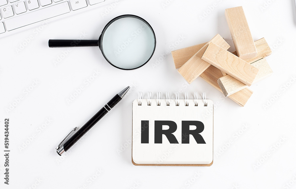 Poster irr word written on notebook with block magnifier and pen , business concept.