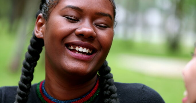 African young woman laughing and smiling outside with friend