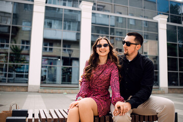 Fototapeta premium Romantic couple is resting sitting on a bench in the city.