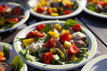 appetizing light salads with strawberries in plates on the table	